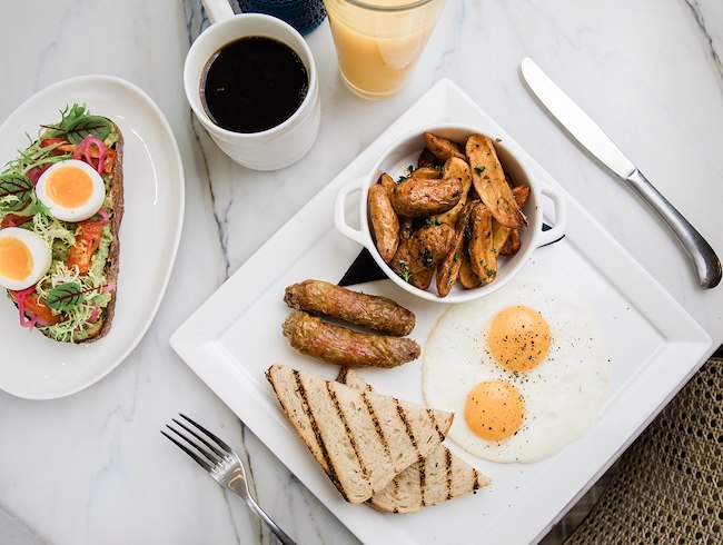 A table with plates of food and drinks HEW Parlor & Chophouse