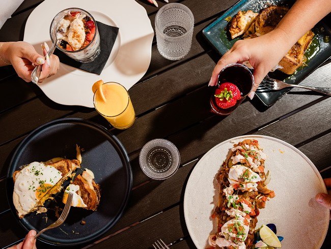 A table with plates of food and drinks HEW Parlor & Chophouse